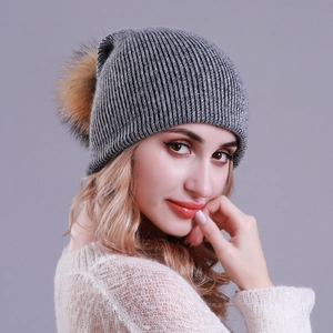 Chic grey ribbed knit beanie with a fluffy brown pom-pom for winter warmth and style