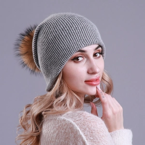 Detail of grey ribbed knit beanie showing high-quality wool texture and fluffy fur pom-pom