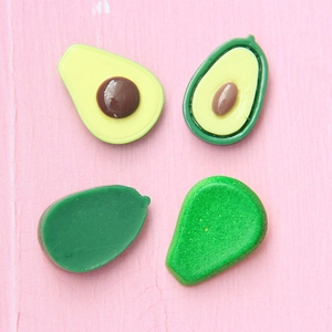 DIY-Avocado-Anhänger aus Harz für Schmuck auf pinkfarbenem Holzhintergrund