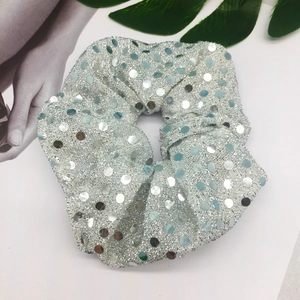 Detail of silver sequined mesh scrunchie with high elastic band for holiday styling