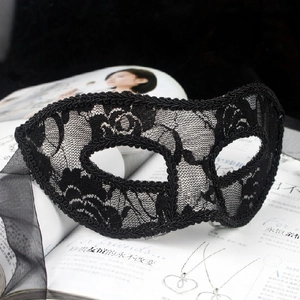 Detailed view of black lace masquerade mask with intricate floral patterns and silk ribbons