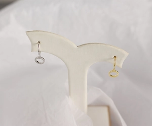 Detailed macro view of S925 sterling silver hoop earrings with zircon pendants in gold and silver