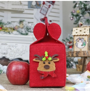 Detail of red Christmas felt gift bag with elk appliqué and heart-shaped handle