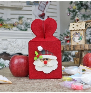 Detail of red felt Christmas gift bag with Santa Claus patch and heart-shaped handle