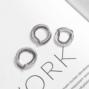 Macro shot of 925 sterling silver rings with polished outer band and braided rope texture