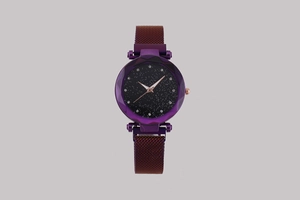 Detail of purple starry sky dial and faceted glass bezel on milanese mesh strap watch