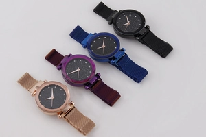 Close-up of starry sky dial watches with Milanese straps in rose gold, purple, and blue