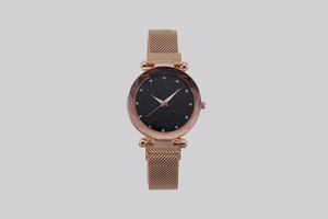 Macro view of rose gold starry sky watch with faceted glass and Milanese mesh band