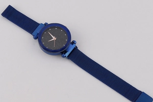 Close-up of starry sky blue watch face with rhinestone markers and milanese mesh strap