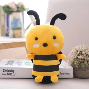 Cute plush bee doll with yellow and black stripes sitting on white books background