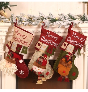 Close-up of three 3D burlap Christmas stockings with Santa, Snowman and Reindeer dolls
