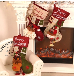 Three festive Christmas stockings with Santa, Snowman and Reindeer by a warm fireplace