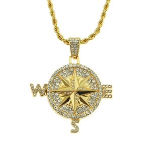 Macro view of gold compass pendant with sparkling rhinestones and twisted chain