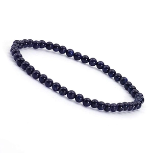 Macro detail of deep blue blue sand stone beaded bracelet with sparkling star effects
