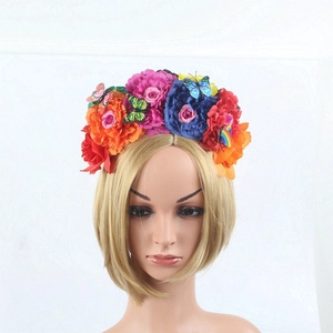 Close-up of Mexican style floral headband with colorful faux peonies and butterfly accents