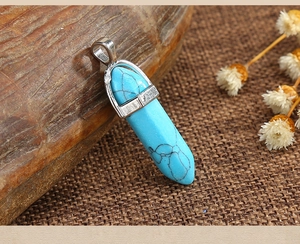 Detailed view of hexagonal blue turquoise stone pendant with silver metal bail