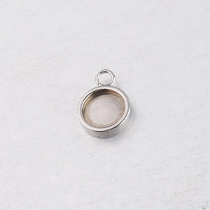 Macro view of a silver stainless steel round pendant base with ring for DIY jewelry