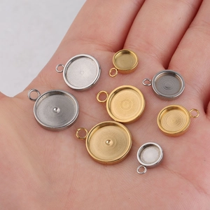 Close-up of gold and silver stainless steel pendant trays in various sizes on a palm