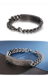 Detailed view of vintage silver stainless steel bracelet with engraved cross and pray plaque