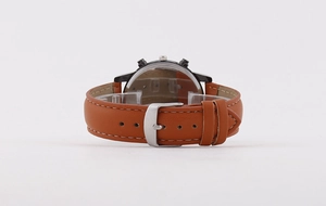 Detail of brown leather watch strap with contrast stitching and silver metal buckle