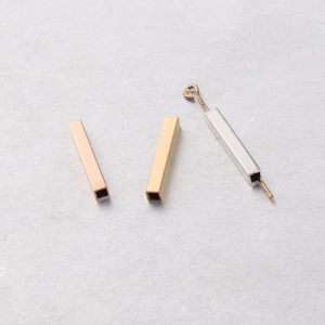 Macro shot of curved square tube beads in gold, rose gold and silver for jewelry making