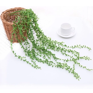 Artificial succulent hanging vine in woven basket with white ceramic tea cup decor