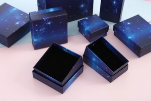 Detailed view of dark blue starry jewelry boxes with black foam inserts and square lids