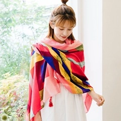 Detail of colorful plaid scarf with fringes featuring soft cashmere-like texture fabric