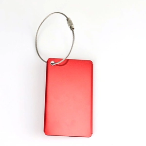 Macro detail of red aluminum luggage tag with secure stainless steel wire screw connector