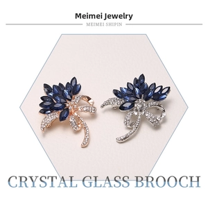 Macro shot of blue marquise crystal flower brooches in gold and silver finish