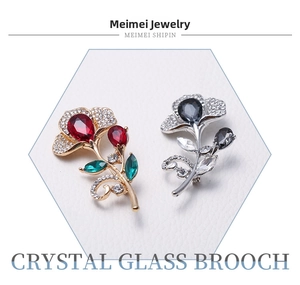Detail of floral crystal glass brooches in red-green and black-silver alloy settings