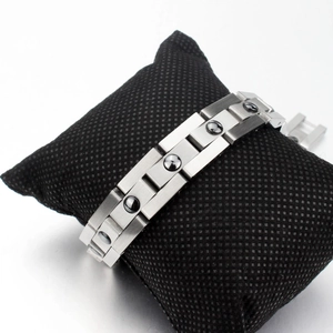 Silver stainless steel magnetic therapy bracelet for men displayed on a black cushion