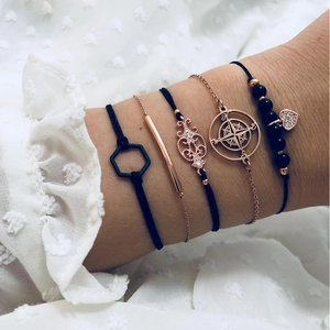 Fünfteiliges Boho-Armband-Set mit Kompass-Anhängern und schwarzen Herzperlen am Damenhandgelenk