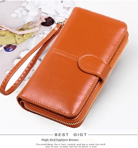 Detail view of brown zip-around long wallet with braided strap and dual compartments