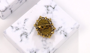 Macro detail of vintage alloy brooch back with secure pin clasp on marble surface