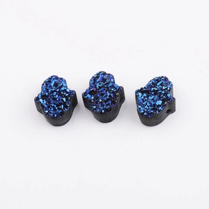 Détail de breloques en résine en forme de main avec texture de cristal druzy bleu brillant