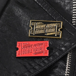 Detailed close-up of science fiction movie ticket enamel pins on a black leather jacket