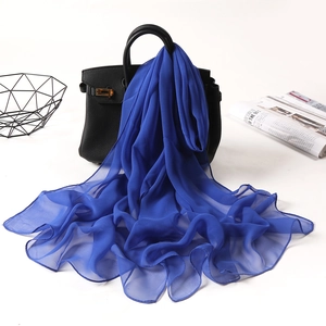 Elegant blue georgette long scarf draped on a black handbag for a stylish fashion look