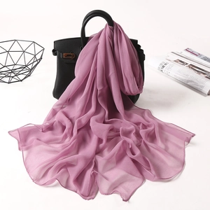 Detail of purple chiffon scarf draped on handbag with elegant lightweight texture