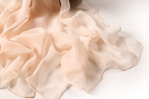 Detail view of the fine edge stitching on a lightweight nude pink chiffon dance scarf