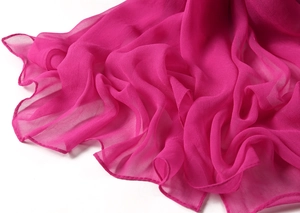 Macro detail of rose red chiffon fabric with delicate wavy edges and light texture