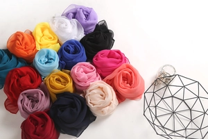 Artistic arrangement of lightweight colorful chiffon scarves shaped like roses in a basket