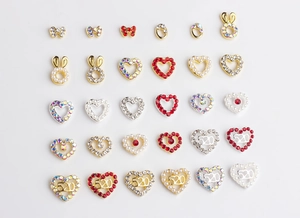 Detailed macro shot of bowknot and heart-shaped nail charms with rhinestones and pearls