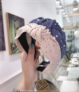 Close-up of knotted fabric headbands in pink and blue with pearls and rhinestones