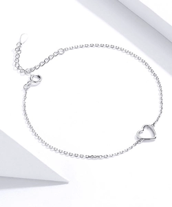 Detailed view of silver hollow heart charm anklet with adjustable chain on white background