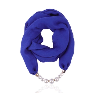Detail of royal blue chiffon scarf featuring elegant pearl beads and golden buckle
