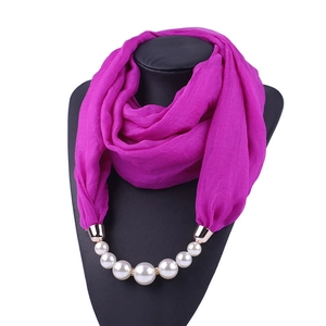 Detail of rose red chiffon scarf necklace with white faux pearls on a black mannequin