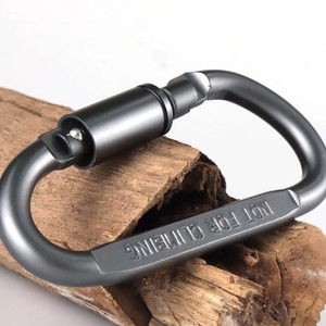 Macro shot of gunmetal aluminum carabiner with Not For Climbing text on wood