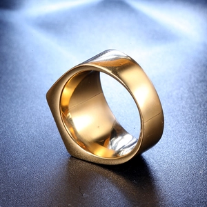Macro shot of wide gold stainless steel ring with polished finish on blue texture