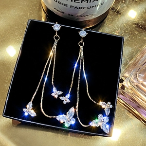 Macro shot of silver butterfly tassel earrings with sparkling cubic zirconia on black velvet